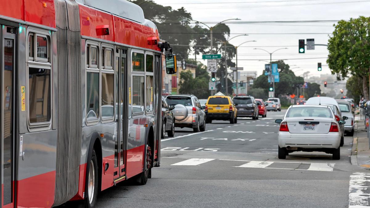 Photo of a bus in a transit lane in the Richmond district with traffic in the adjoining lane