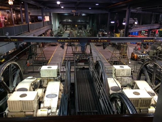 Cable car gearboxes and mechanical equipment displayed in the repair barn facility.
