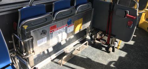 A Muni Operator secures a wheelchair passenger in a securement area A curbside wheelchair securement area