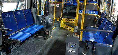 Priority Seating decal on Muni bus. Priority seating on a New Flyer bus: blue seats with decals showing a wheelchair user, pregnant person, and person using a cane