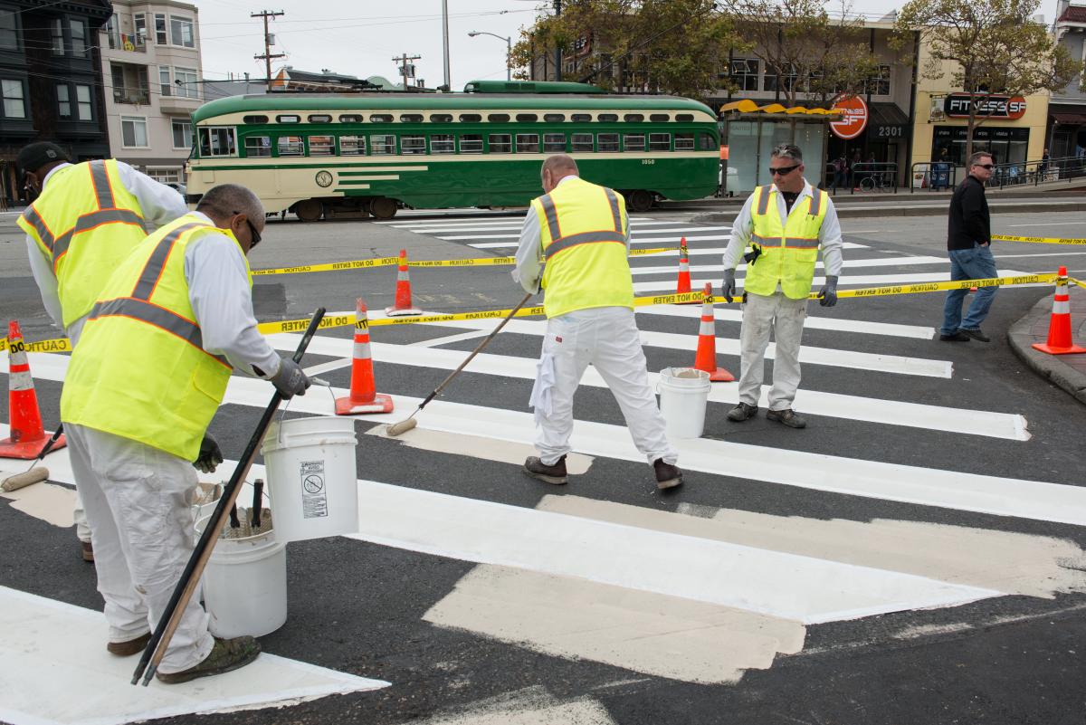 SFMTA workers painting pedestrian safety area