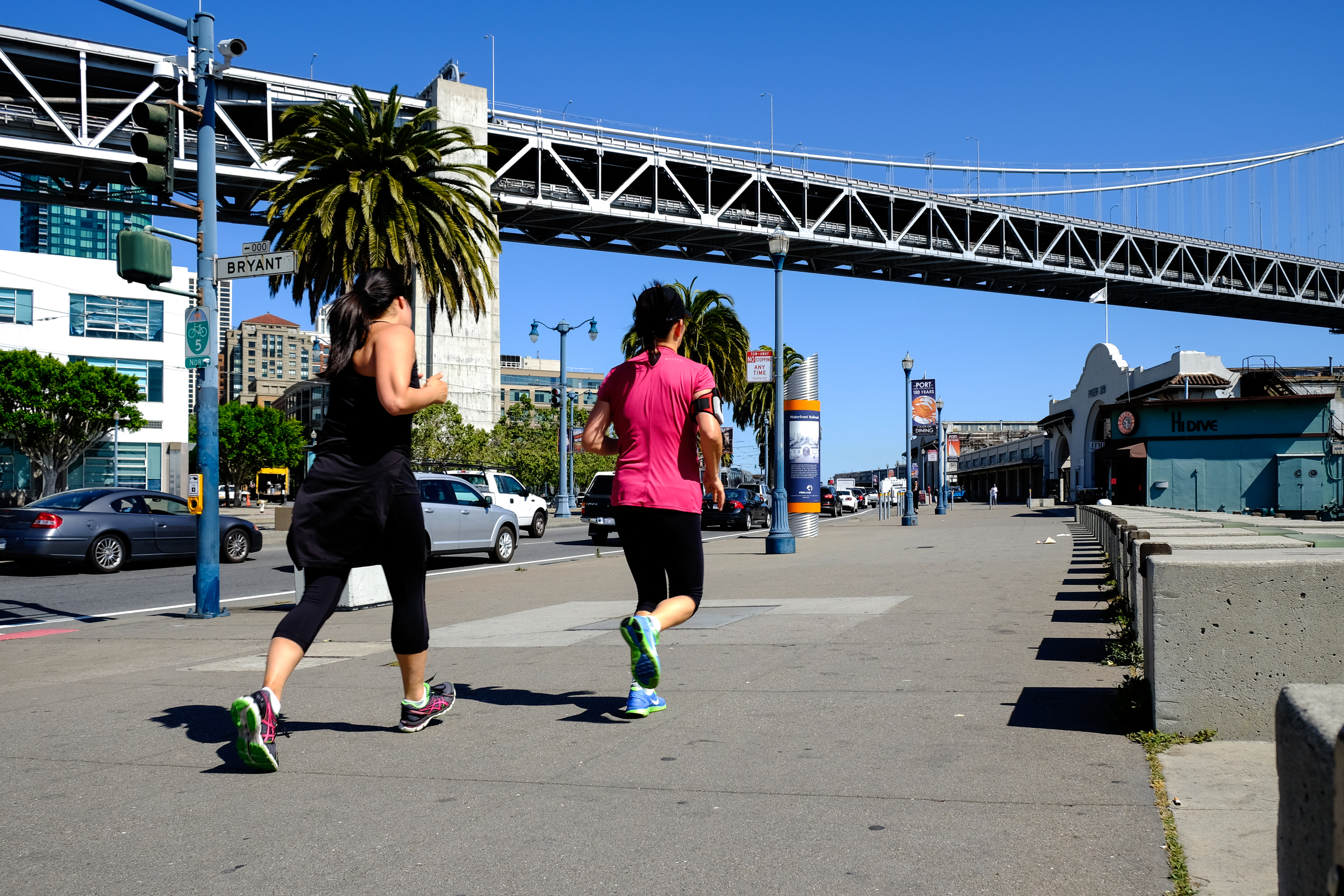 Two women jogging along the east side of The Embarcadero south of the Bay Bridge