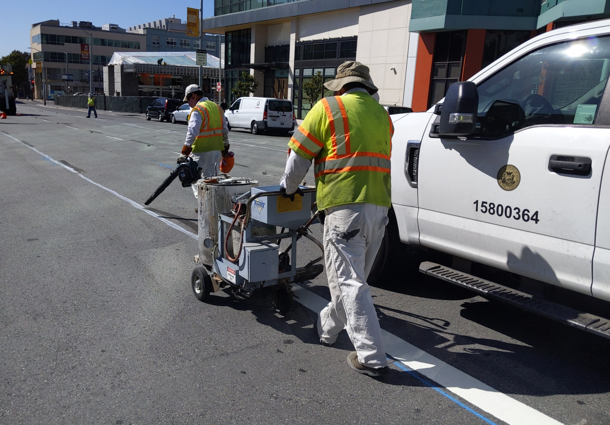 Work crews paint transit lane on 4th Street
