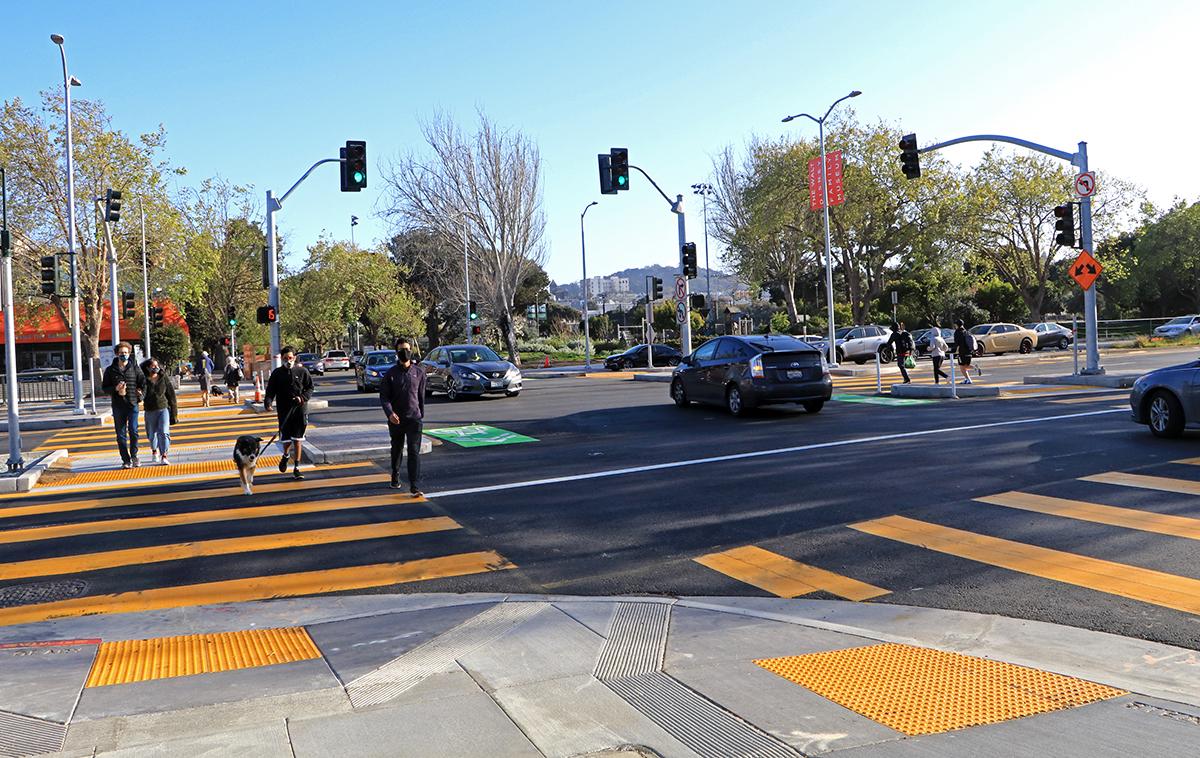 Photo of people using new crosswalks at Geary and Steiner, with the Steiner bridge removed