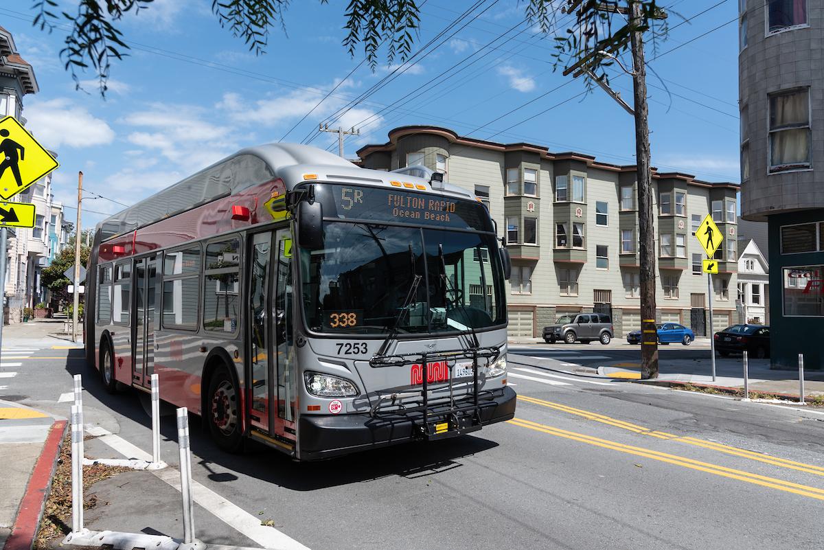 A photograph of the 5R  Fulton Rapid driving through the intersection of McAllister and Lyon streets in San Francisco.