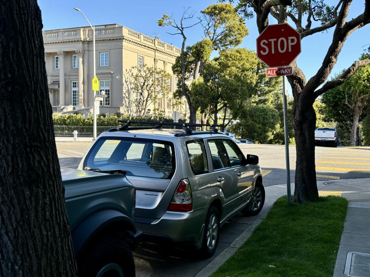 A car parked next to a stop sign.