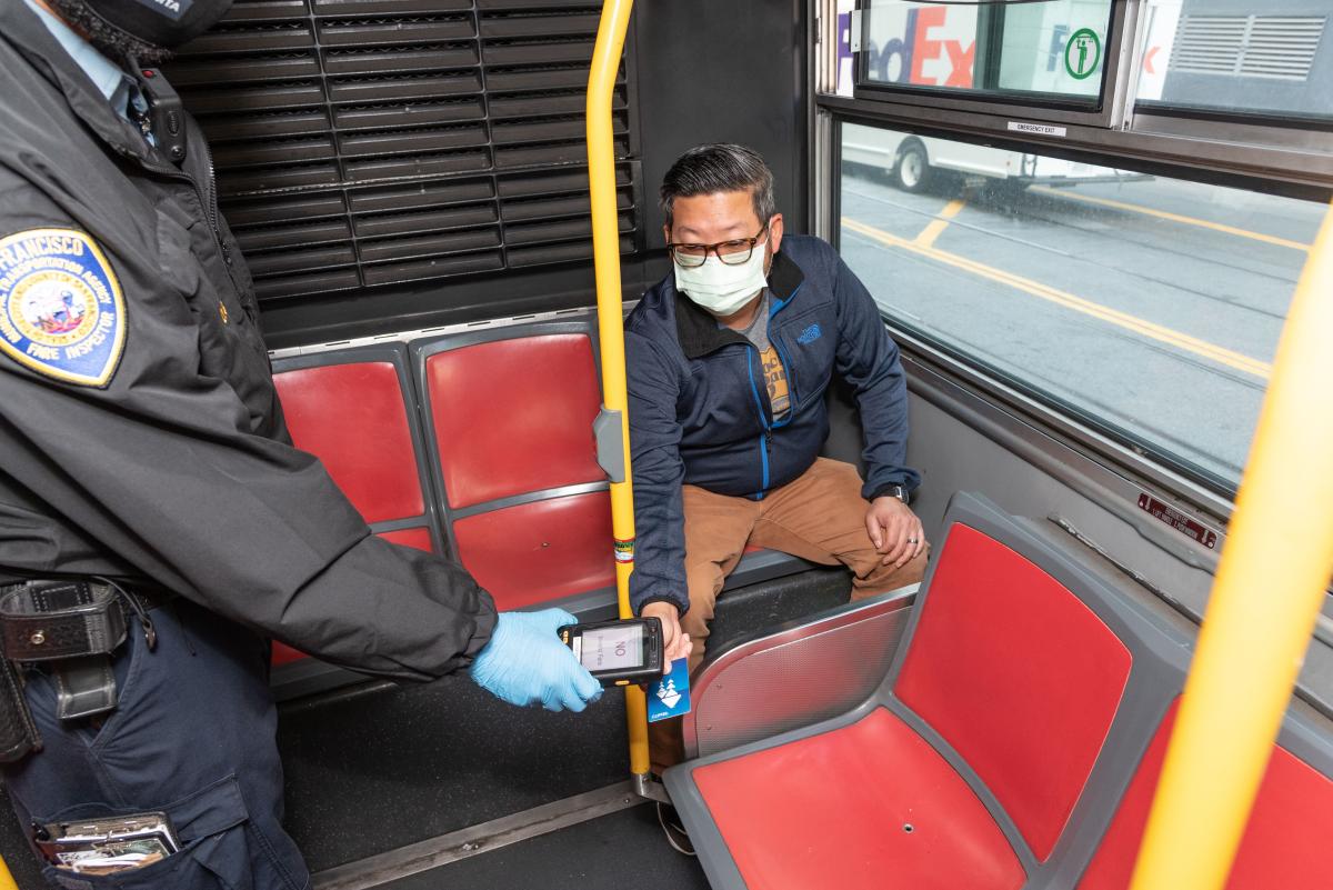 Inspector checks fare on a rider's Clipper Card. 