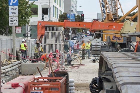 Workers use a crane to put piping in place during slurry wall excavations on 4th Street. The walls being built are a portion of the future Yerba Buena/Moscone Station.