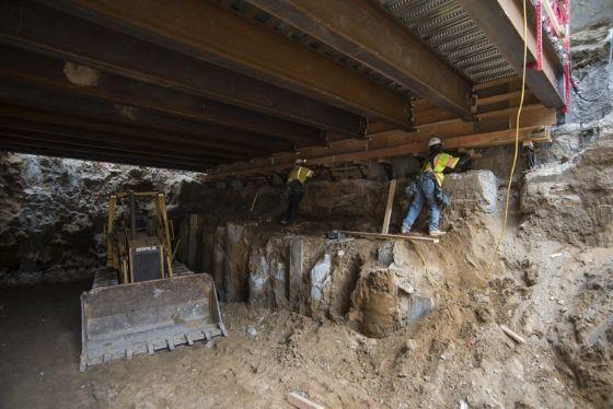 Under Stockton Street, excavation of the Union Square/Market Station continues. Workers have laid metal sheeting on top of roof beams.