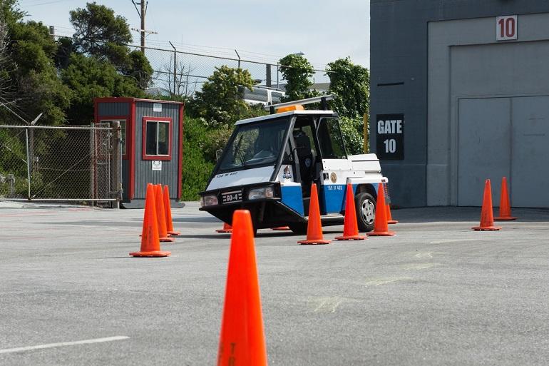 PCO Go-4 vehicle navigating through orange traffic cones during a safety roadeo obstacle course.