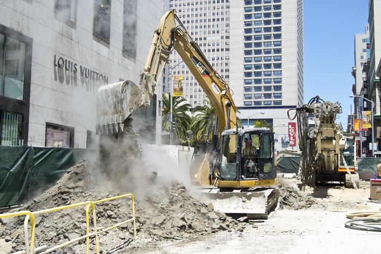 Excavator loading debris from construction site on Stockton Street in downtown San Francisco.