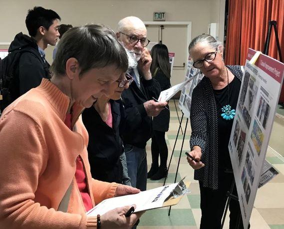 Attendees review transit project information boards at a public open house meeting.