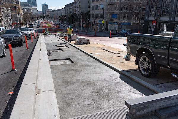 Looking south at crew member laying concrete between Eddy and Larch on Van Ness.