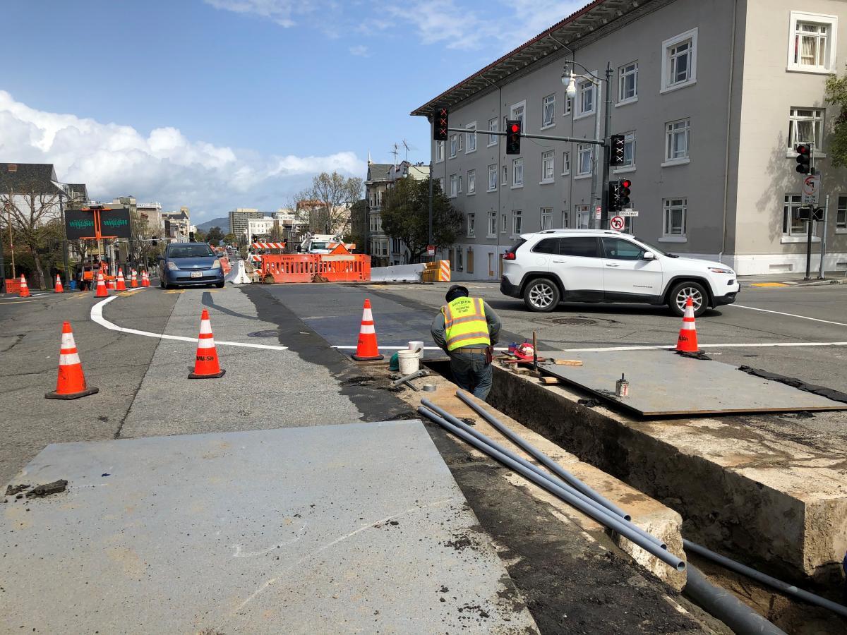 Crew member installing irrigation sleeves along Van Ness at Broadway