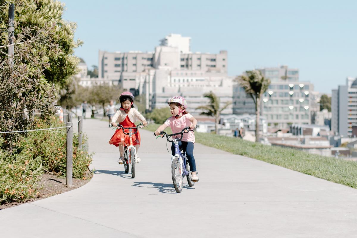 Young bicyclists on a road biking with helmets