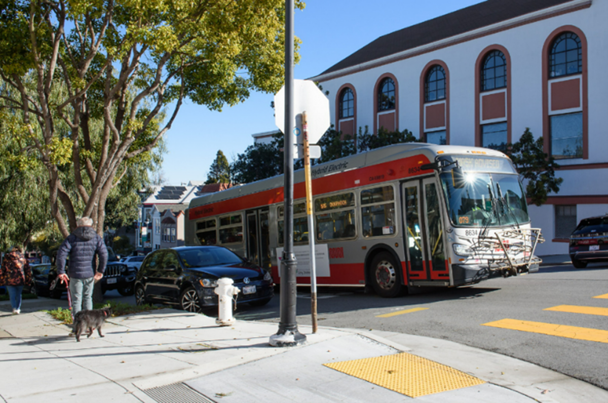 Photo of a flag stop with a bus stopped in the travel lane. 