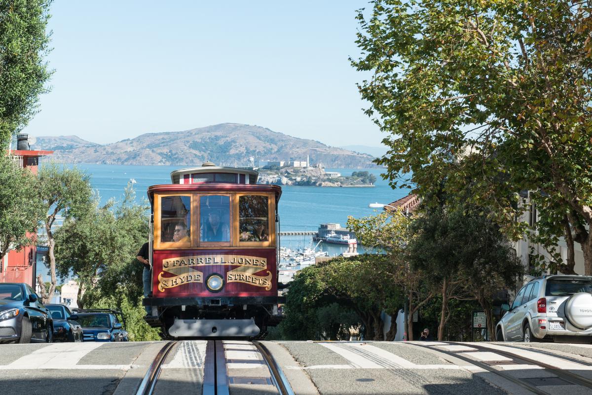 A cable car crests a hill in San Francisco