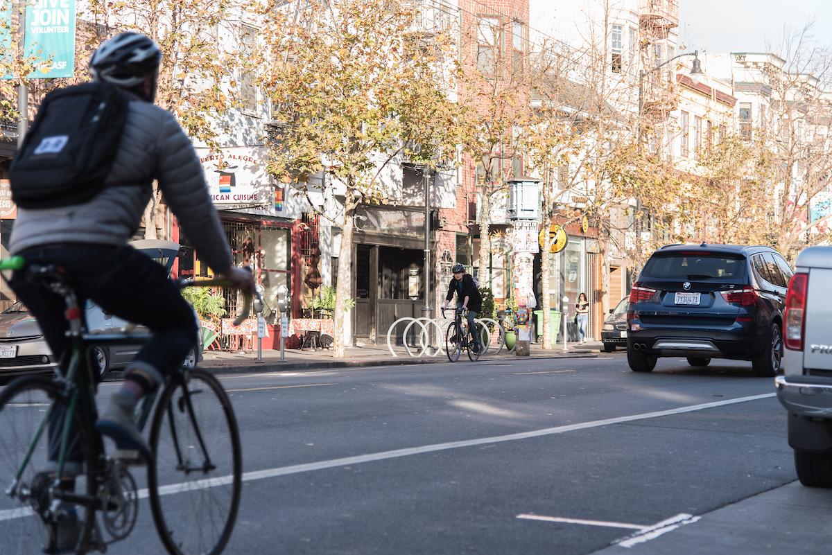 A cyclist and vehicle on Valencia Street