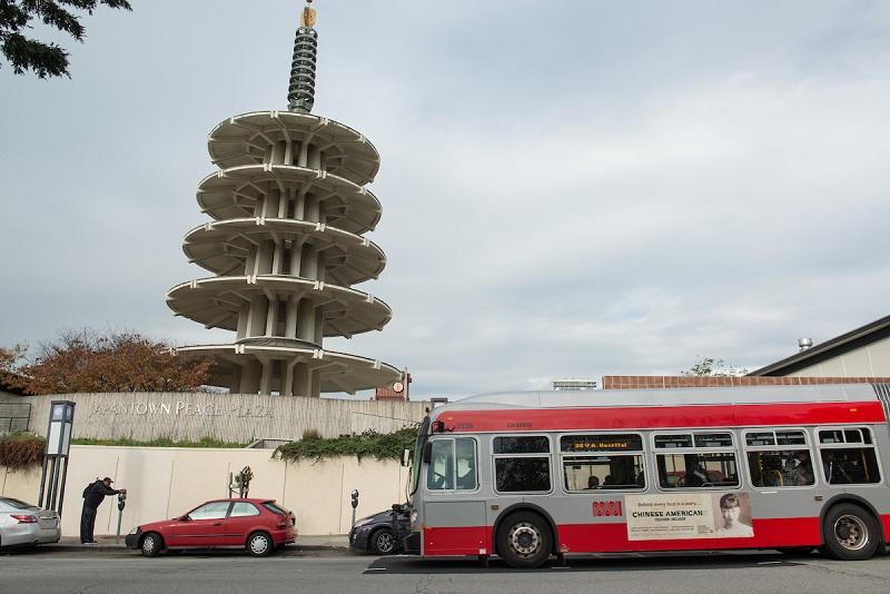 A 38 Geary coach stopping outside of Japantown.
