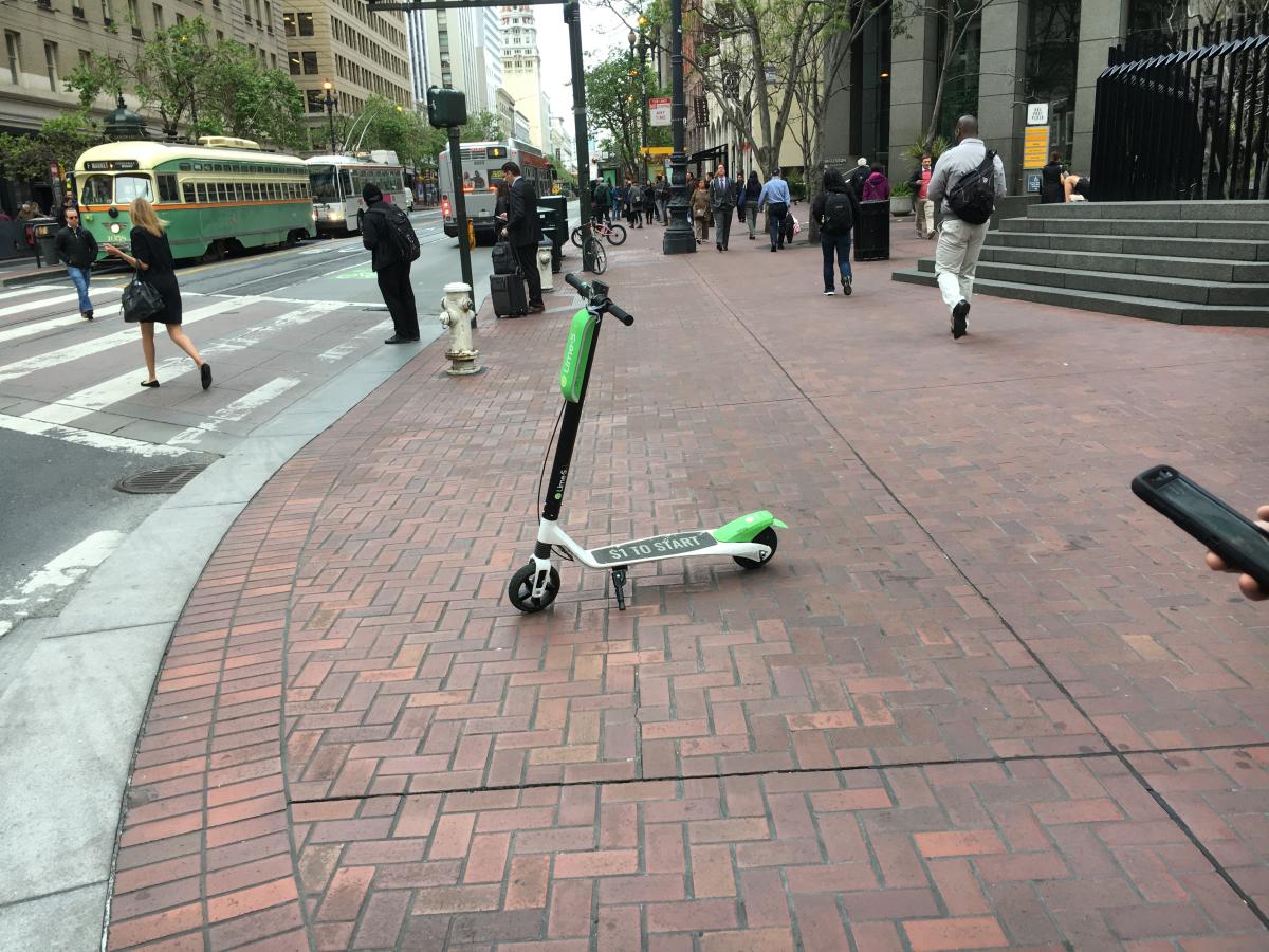 A Lime scooter parked on a Market St. sidewalk