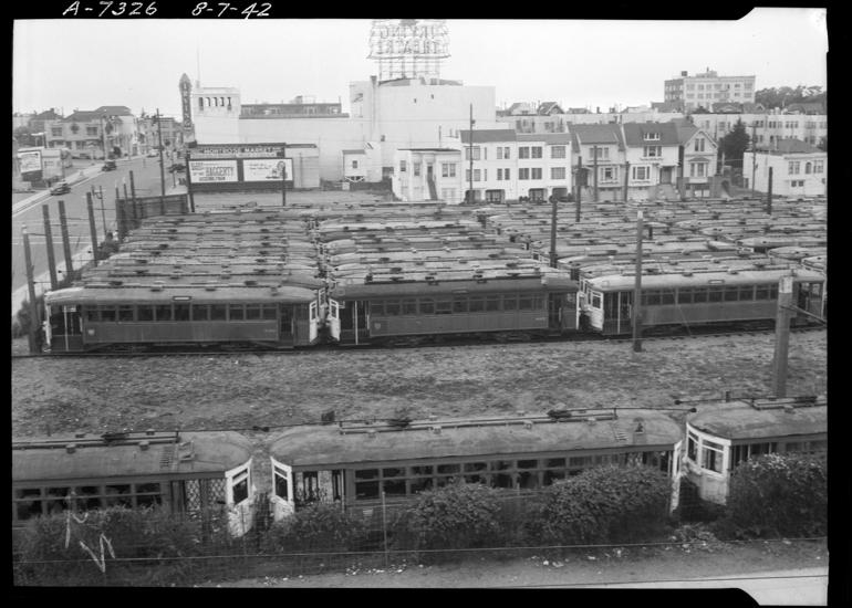 derelict streetcars sit in a large empty lot