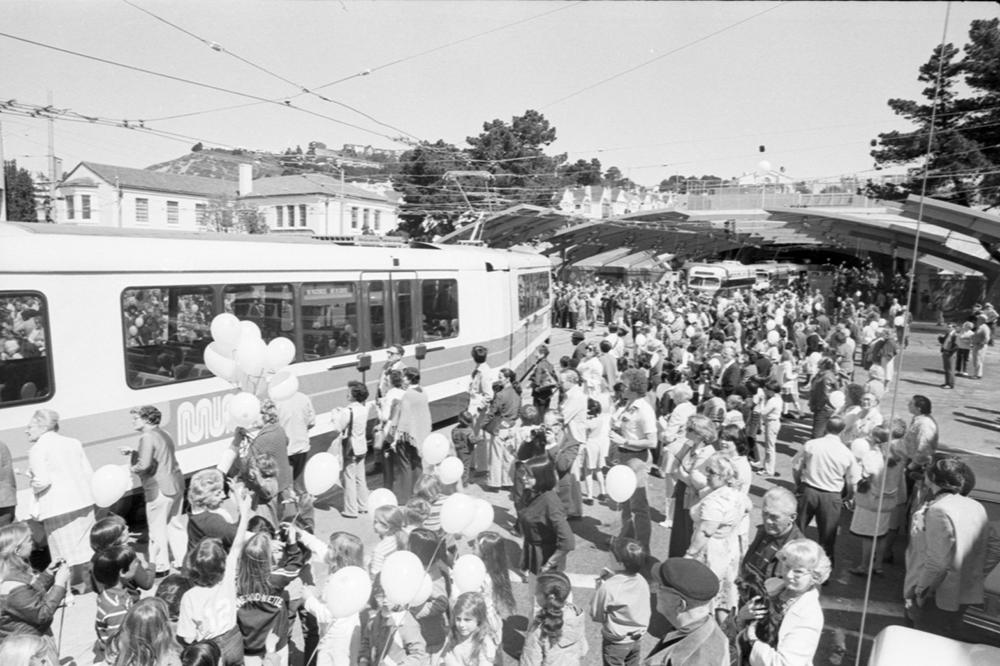 crowd of people outside new west portal station with LRV train
