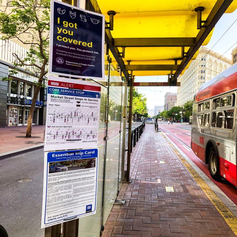 Photo of face mask, wayfinding and ETC signs at a boarding island on Market Street.