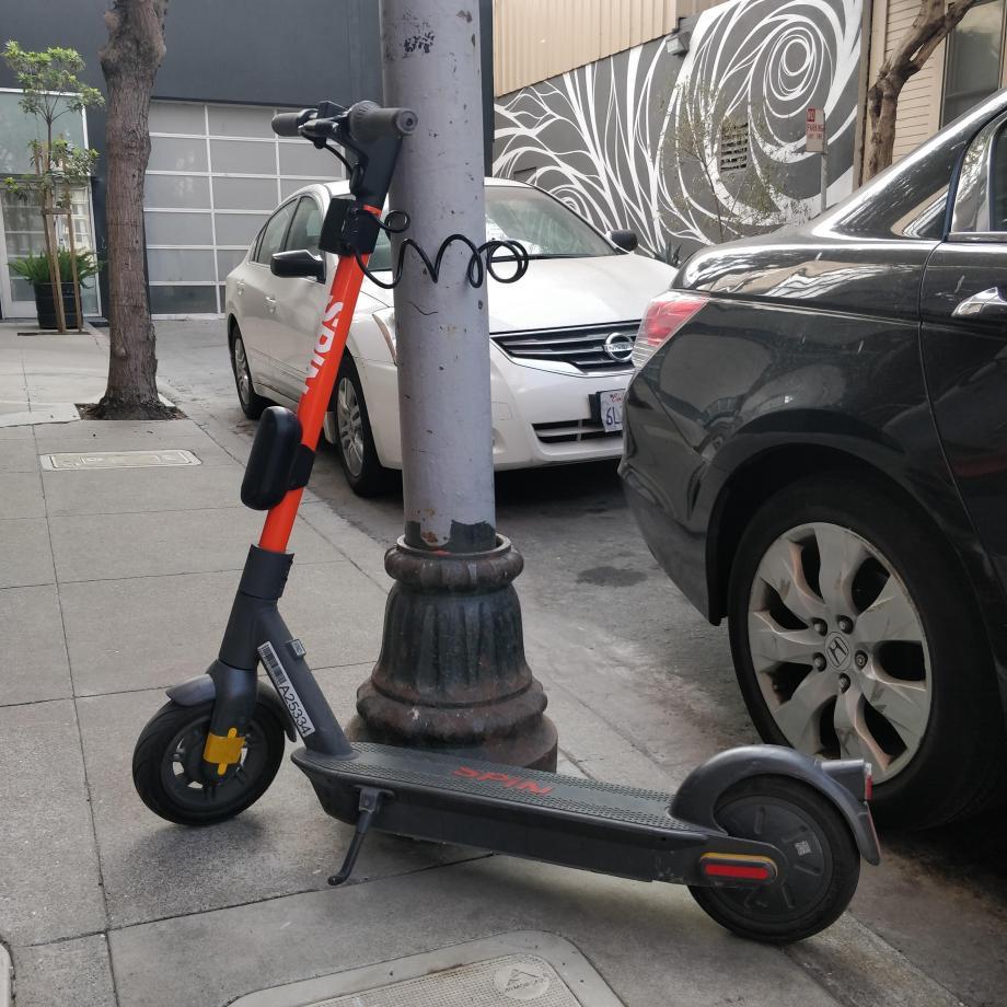 A Spin scooter parked with a lock-to device