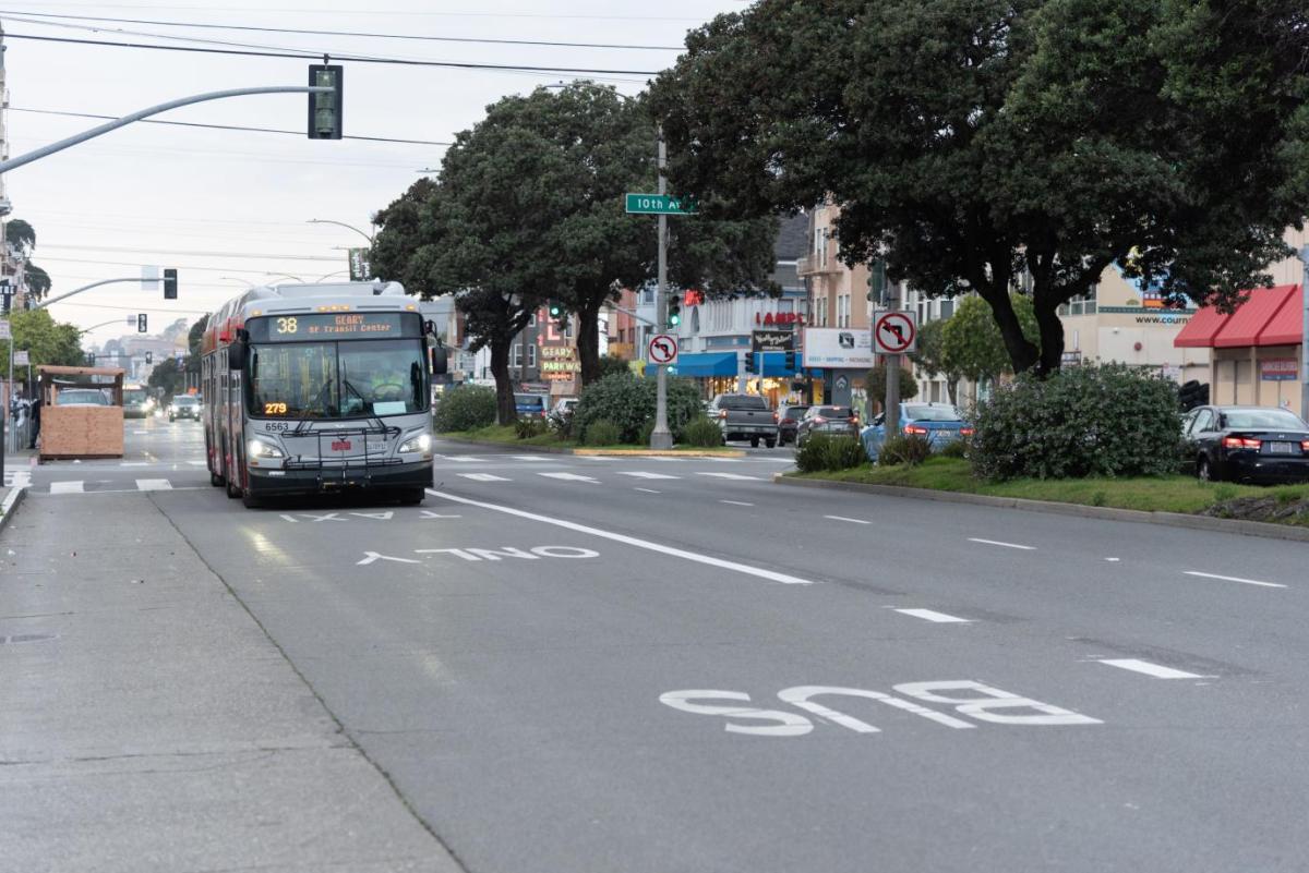 Photo of the 38 Geary in a transit lane passing a shared space dining area