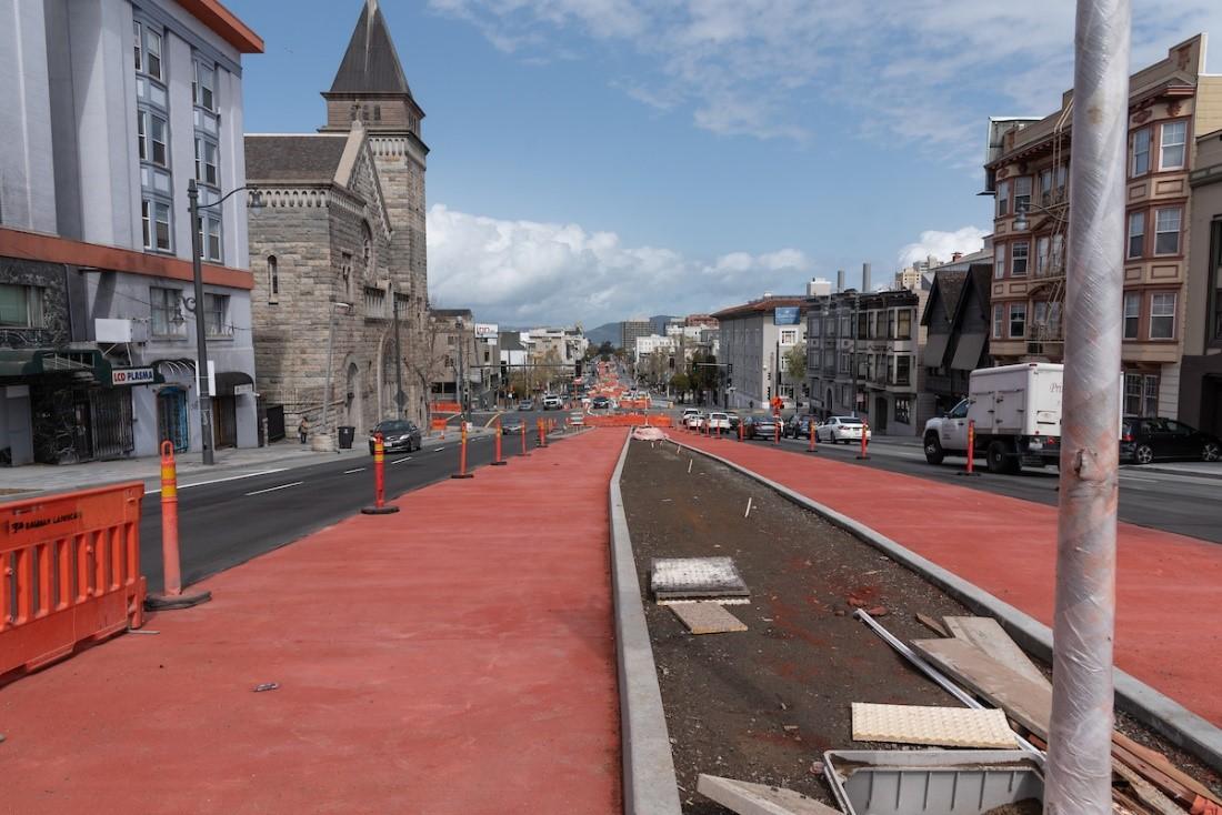 Photo of red concrete freshly poured on Van Ness Avenue which will serve as transit lanes for the bus rapid transit system