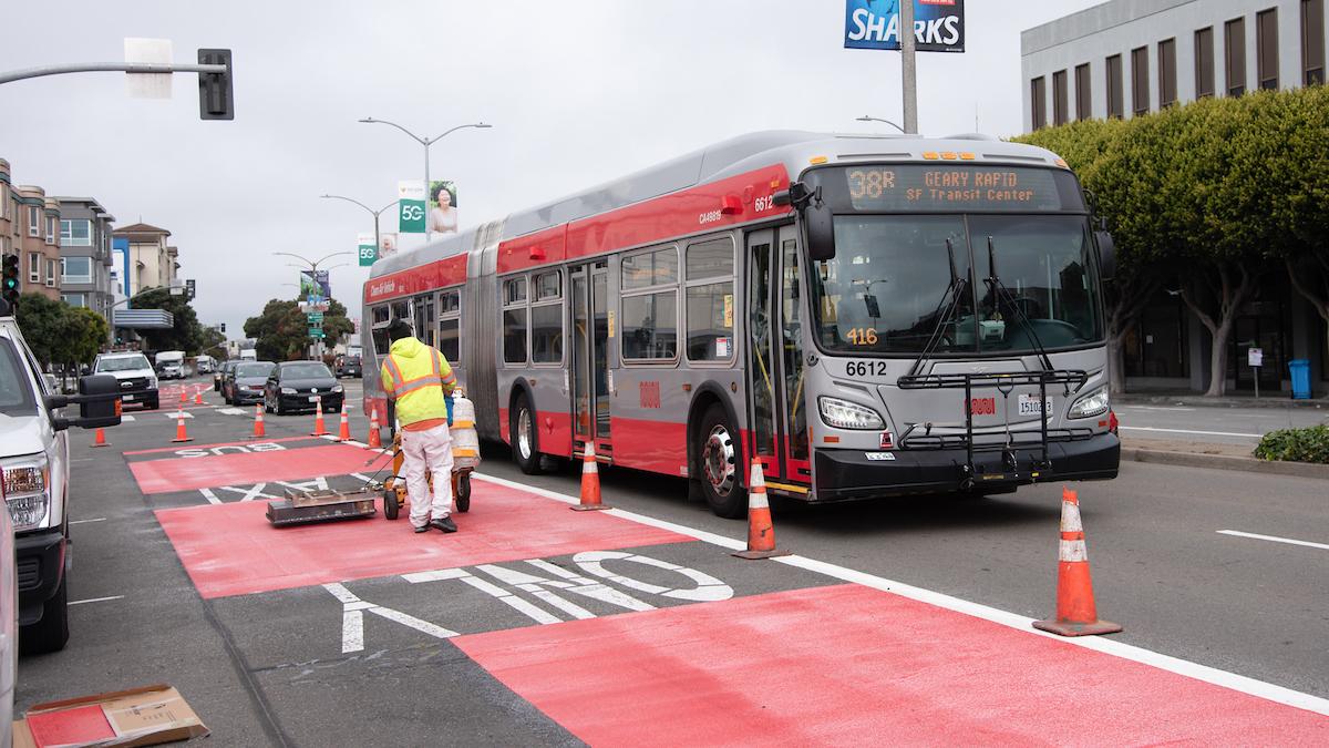 Photo of crew striping red paint on Geary Boulevard
