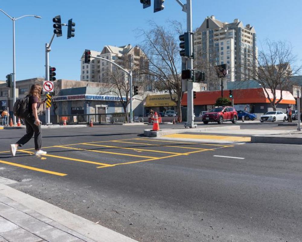Image of person crossing the new surface-level crosswalk at Steiner