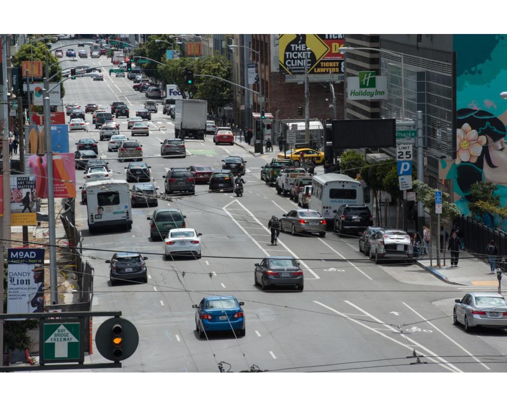 8th Street before: three travel lanes, cyclist riding in a bike lane, a car is traveling across the bike lane.