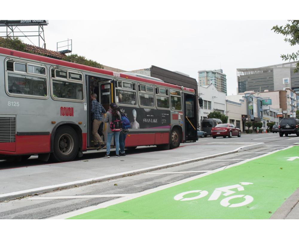 7th Street after: bus riders board Muni bus from a transit boarding island