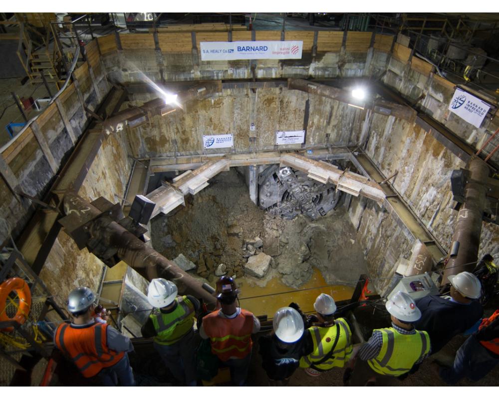 Project and agency staff watch TBM Big Alma emerge inside the North Beach retrieval shaft in 2014.