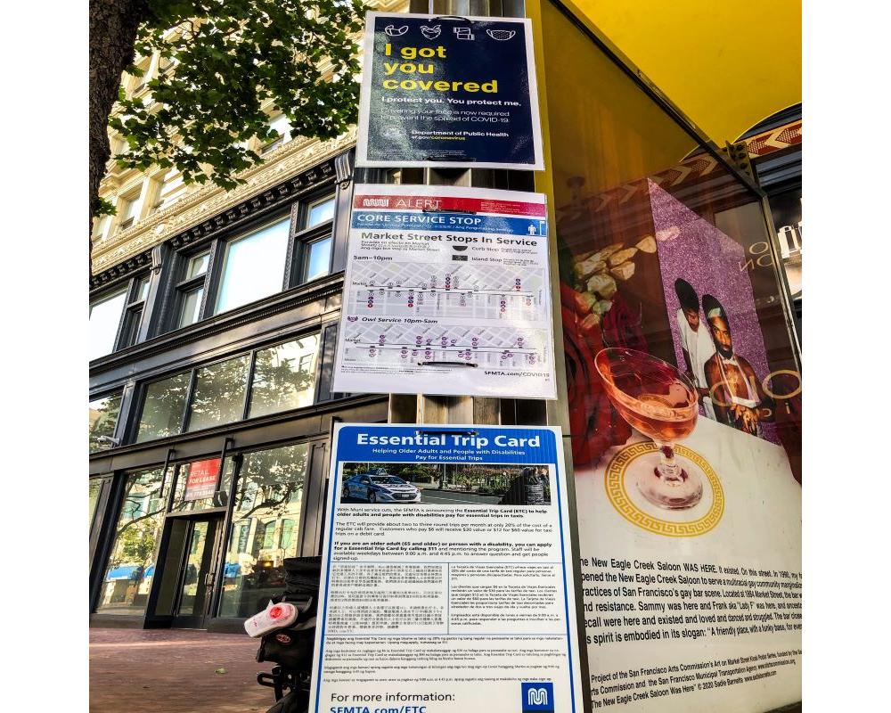 Photo of face mask, wayfinding and ETC signs at a bus stop on Market Street.