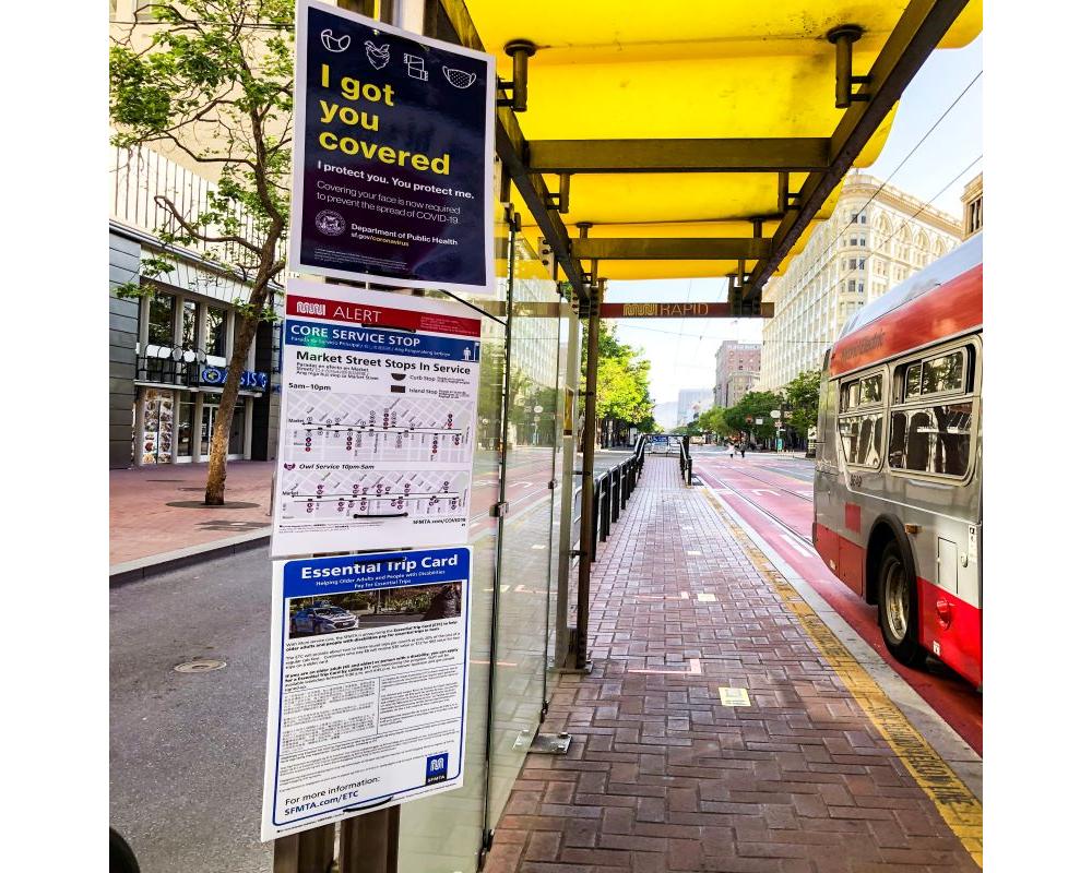 Photo of face mask, wayfinding and ETC signs at a boarding island on Market Street.