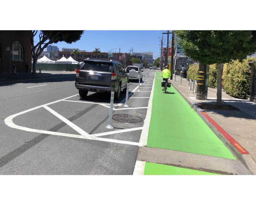 7th Street after: bicyclist riding in a protected bikeway with green paint