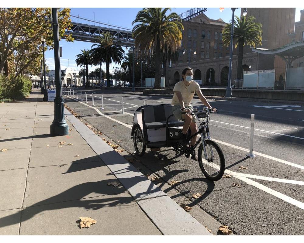 person riding a pedicab along the Embarcadero