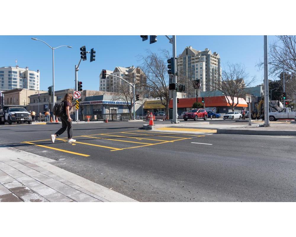 Image of person crossing the new surface-level crosswalk at Steiner