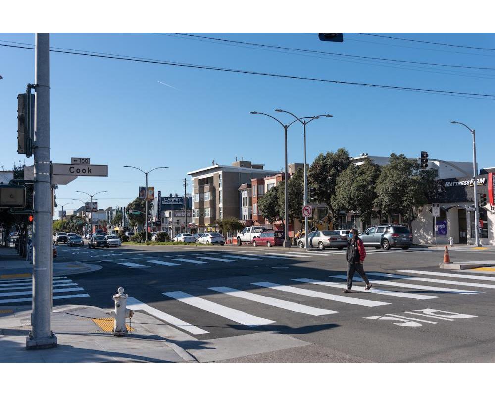 Image of woman crossing at a new crosswalk at Cook Street