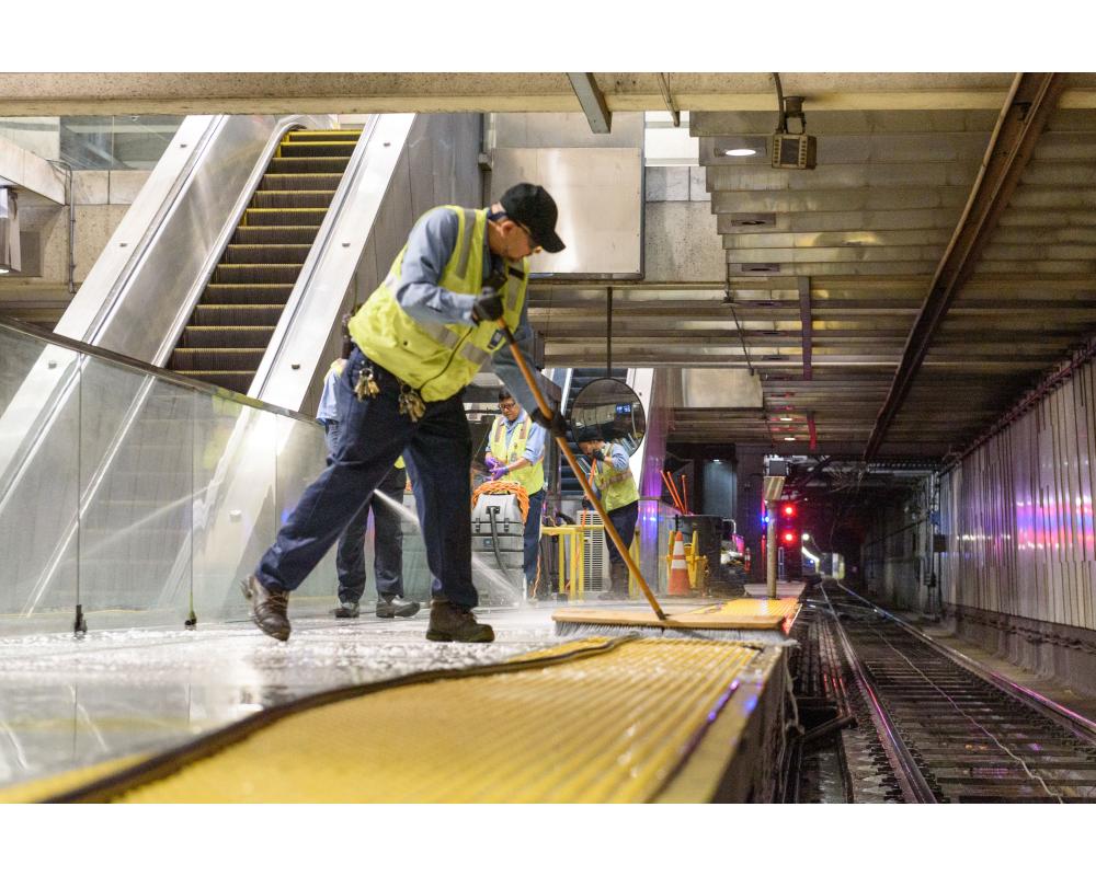 Custodial staff cleaning Embarcadero Station platform.