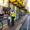 Photo of a Market Street Ambassador posting new face mask, ETC, and wayfinding signage on a boarding island bus stop.