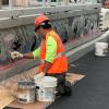 Photo of A worker installing mosaic on the ADA Platform at 40th Avenue