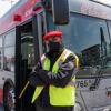 Operator standing in front of bus with open doors