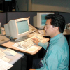 Man sitting at an 1990s-era computer.