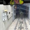 Muni Metro train tracks leading into tunnel opening with sign that says stop here acquire A.T.C.S.