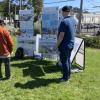 a group of people in a park setting view informational boards