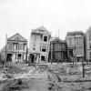 black and white photo of houses damaged and leaning after the 1906 earthquake and fire