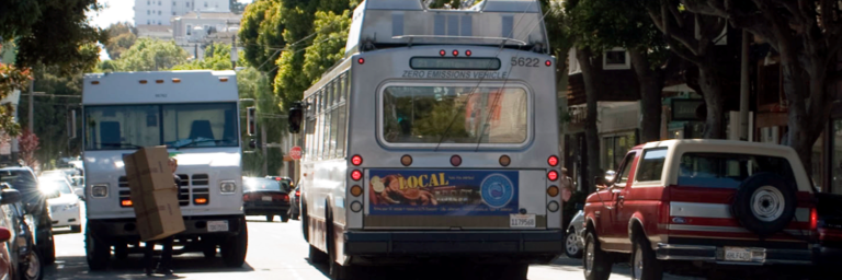 Bus weaves around double-parked vehicles on Hayes Street